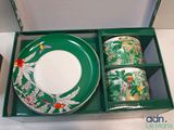 two cups and a plate in a green box