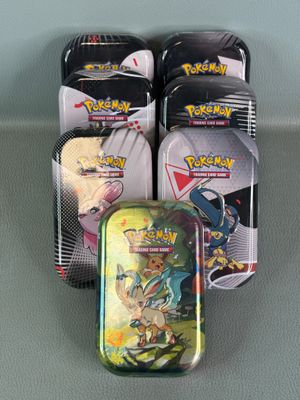 several tins of pokemon cards are sitting on a table