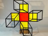 une image représentant une croix composée de cubes, posée sur un socle en bois