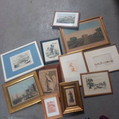a lot of framed pictures on the floor next to a pair of shoes