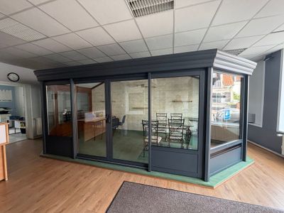 une pièce avec une table, des chaises et une grande porte vitrée