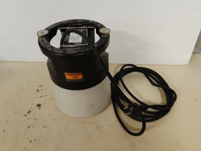 a black and white sprayer sitting on top of a counter next to a white wall