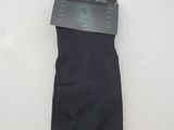 a pair of black socks on a white surface with a black tag