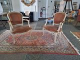 two chairs that are sitting on a rug in a room