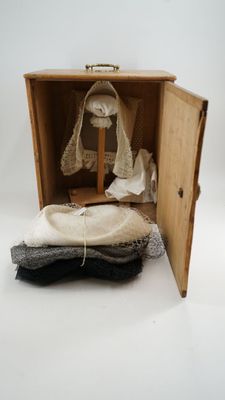 a small wooden box with a pair of shoes inside of it