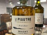 a bottle of whisky sitting on a table in front of two bottles