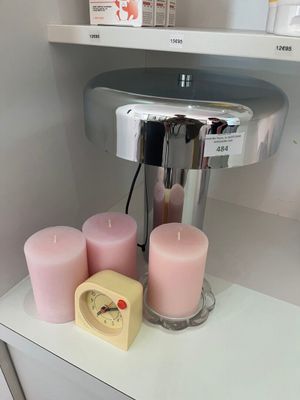 des bougies et une horloge posées sur une étagère dans une salle de bains