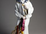 une vieille figurine représentant un homme avec une guitare, posée sur une table