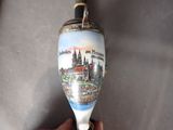 a hand holding a glass with a picture of a castle on it