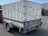 un camion dont l'arrière est recouvert d'une bâche, garé sur un parking