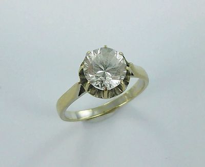 a close up of a diamond ring on a white surface