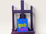 chevalet violet sur lequel est peinte une image représentant un crabe et un papillon