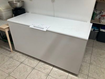 un congélateur coffre blanc dans une cuisine au sol carrelé