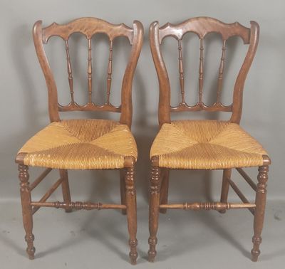 pair of antique wooden chairs with wicker seat and backs