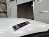 a sticker on the hood of a car in front of a garage door