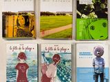 Plusieurs livres sont alignés sur une table recouverte d'une nappe blanche.