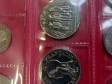 six different coins in a plastic case on a red surface
