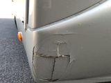 a close up of a silver bus with a hole in the side
