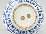 blue and white vase with a circular design on the outside of it