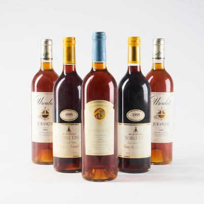 trois bouteilles de vin posées les unes à côté des autres sur une surface blanche