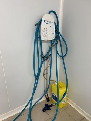 a blue hose attached to the wall next to a yellow bucket