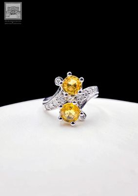un gros plan d'une bague ornée de deux pierres jaunes