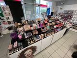 a display of cosmetics products in a store with a woman ' s face painted on the wall