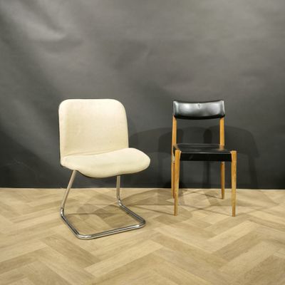 two chairs sitting next to each other in front of a black wall
