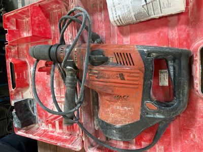 a drill that is attached to a red piece of equipment