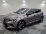 Une voiture grise est garée dans une pièce au sol carrelé en damier.