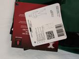 a green bag with a red and black label on it