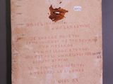 an old book with writing on it sitting on a table
