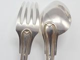 two silver spoons and a fork on a white surface