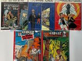 several comics are lined up on a table in front of a white background