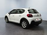 the rear of a white car is parked in a room