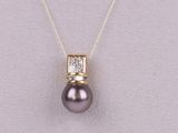 un pendentif composé d'une perle noire et de diamants, monté sur une chaîne en or