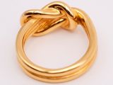 an image of a gold ring with a knot in the middle