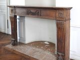 a fireplace in the middle of a room with a clock on the wall