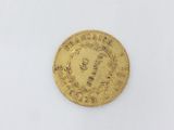 a close up of a gold coin on a white surface