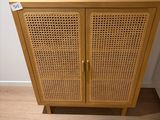 une armoire en bois munie d'une porte en rotin