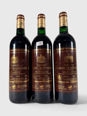 trois bouteilles de vin posées les unes à côté des autres sur une surface blanche