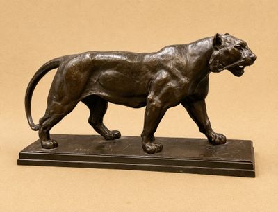 bronze statue of a lion on a marble base on a beige background