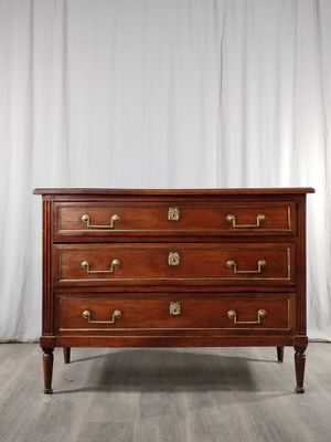 une commode ancienne en acajou avec des poignées en laiton
