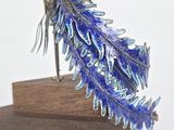 a bird that is sitting on a wooden stand