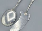 two spoons and a spoon rest on a gray surface