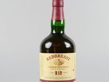 gros plan d'une bouteille de whisky sur une surface blanche