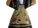 a figurine of a woman in a dress on a rock