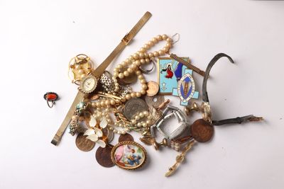 a pile of assorted jewelry on a white surface
