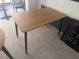 a wooden table with a blackboard on the wall