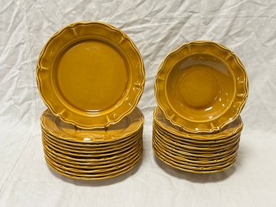 des assiettes plates jaunes empilées les unes sur les autres sur un fond blanc